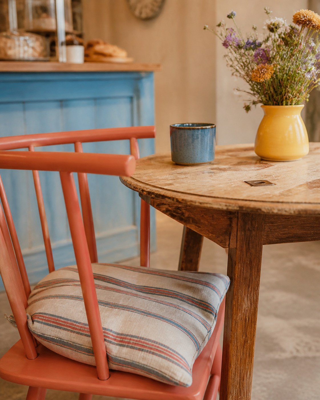 Farbige Stühle, Keramik und Blumen im Café